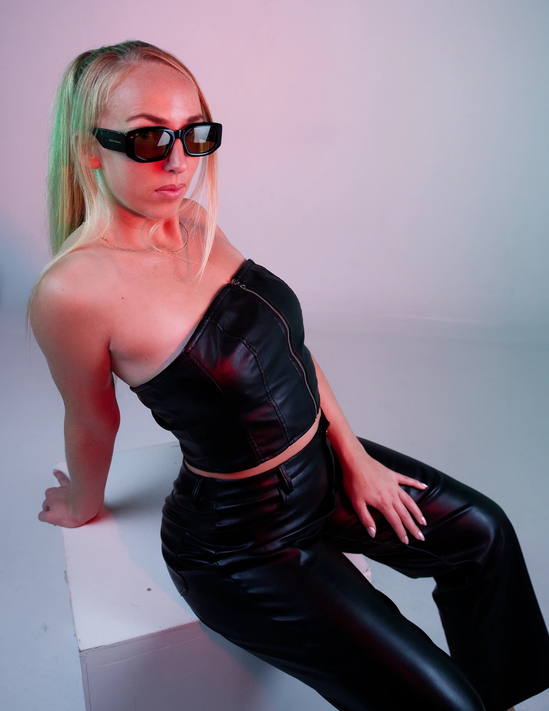 DJ Kiki in sunglasses and a black outfit, studio portrait